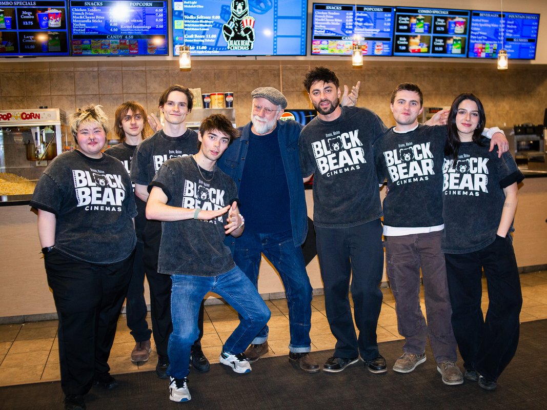 The cast of Saving Black Bear pose for a group photo in the lobby of Black Bear Cinemas
