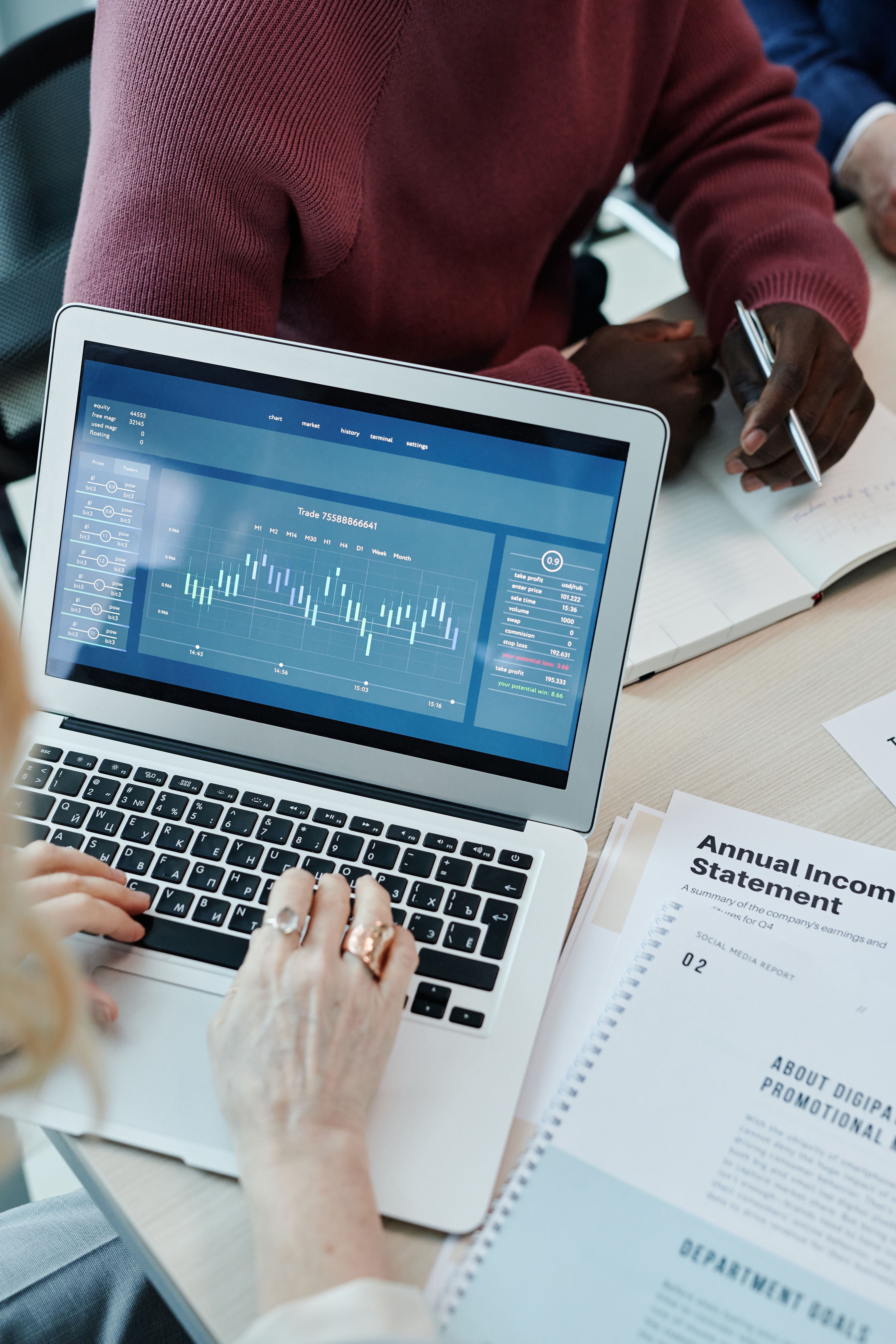 Profissionais consultando indicadores e relatorios em notebook